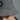 Close-up of a person wearing a grey tweed bucket hat decorated with sparkling crystals and a black hexagonal logo.
